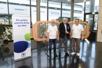 Matthias Müller, Peter Haas und Peter Kupczyk stehen vor der größten optischen Brille der Welt (Bild: KD Busch)